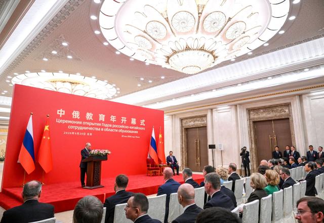 In this pool photograph distributed by the Russian state agency Sputnik, Russia's President Vladimir Putin and China's President Xi Jinping attend the opening ceremony of the Years of Russian-Chinese Cooperation in Education in Beijing on May 20, 2026. (Photo by Kristina Solovyova / POOL / AFP)