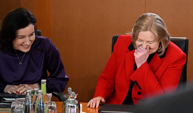 German Minister for Research, Technology and Aerospace Dorothee Baer (L) and German Minister for Labour and Social Affairs Baerbel Bas share a laugh prior to the weekly cabinet meeting at the Chancellery in Berlin on May 20, 2026. (Photo by Tobias SCHWARZ / AFP)