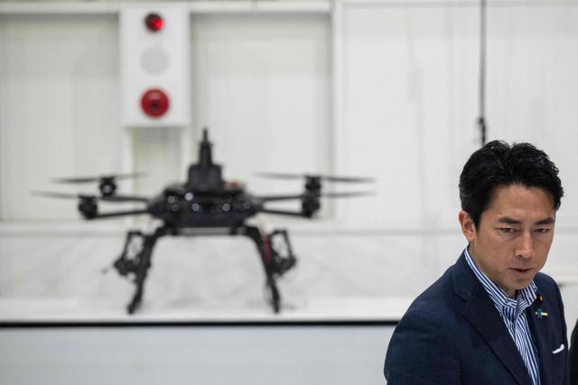 Japan's Defense Minister Shinjiro Koizumi looks at drones at the Prodrone research facility in Nagoya on May 20, 2026, as Japan pushes to expand military drone capabilities with nearly USD 850 million earmarked for unmanned defense systems in its 2026 defense budget. (Photo by ANDREW CABALLERO-REYNOLDS / AFP)