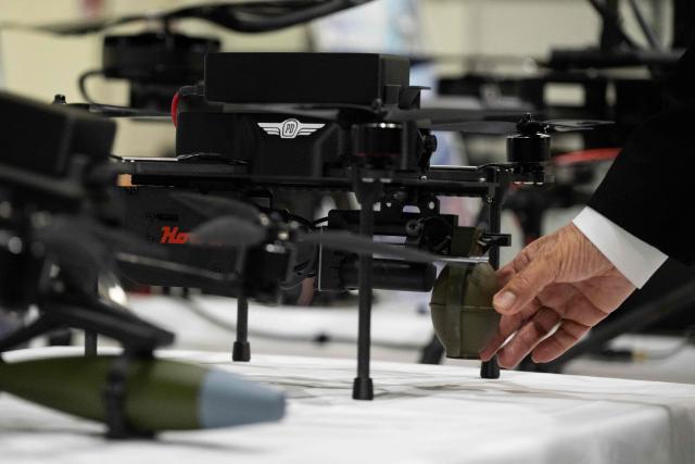 Shunsuke Toya, CEO and President of Prodrone, holds a dummy grenade on a prototype drone at the Prodrone research facility in Nagoya on May 20, 2026, as Japan pushes to expand military drone capabilities with nearly USD 850 million earmarked for unmanned defense systems in its 2026 defense budget. (Photo by ANDREW CABALLERO-REYNOLDS / AFP)