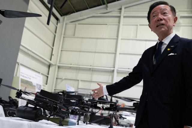Shunsuke Toya, CEO and President of Prodrone, points to armed drone models at the Prodrone research facility in Nagoya on May 20, 2026, as Japan pushes to expand military drone capabilities with nearly USD 850 million earmarked for unmanned defense systems in its 2026 defense budget. (Photo by ANDREW CABALLERO-REYNOLDS / AFP)