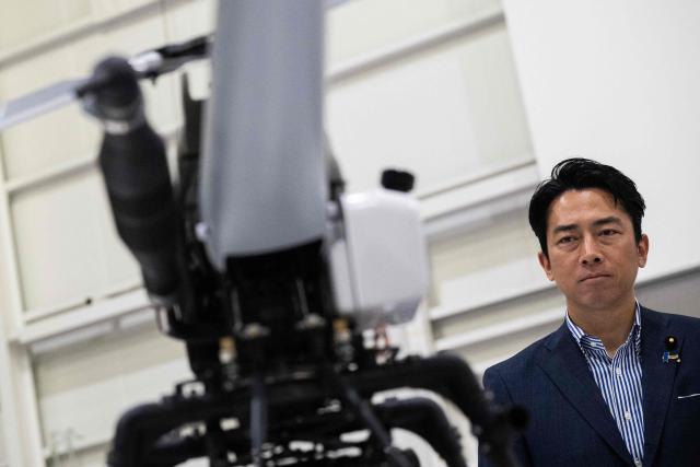 Japan's Defense Minister Shinjiro Koizumi looks at drones at the Prodrone research facility in Nagoya on May 20, 2026, as Japan pushes to expand military drone capabilities with nearly USD 850 million earmarked for unmanned defense systems in its 2026 defense budget. (Photo by ANDREW CABALLERO-REYNOLDS / AFP)