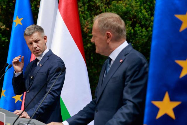 Hungary's Prime Minister Peter Magyar (L) and Poland's Prime Minister Donald Tusk (R) hold a joint press conference at the garden of the Prime Minister's residency in Warsaw, Poland, on May 20, 2026. Hungary's new Prime Minister Peter Magyar is on a two-day visit to Poland for his first official trip abroad, hoping to mark his country's re-alignment with the European Union after years of open conflict under his predecessor. (Photo by Wojtek RADWANSKI / AFP)