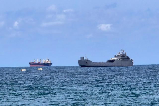 An Israeli naval vessel (R) is motored towards the Israeli port of Ashdod, about 40 kilometres south of Tel Aviv, on May 20, 2026, after Israeli forces intercepted the Gaza-bound Global Sumud Flotilla. Israeli authorities have begun detaining hundreds of activists seized from a Gaza-bound flotilla at the southern port of Ashdod on May 20, a rights group said, after Israeli forces intercepted their vessels at sea. The Global Sumud Flotilla set sail from Turkey last week in the latest attempt by activists to breach Israel's blockade of the Palestinian territory, after Israeli forces intercepted a previous convoy last month. (Photo by Nir KAFRI / AFP)