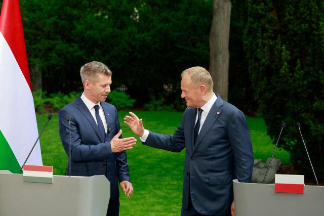 Hungary's Prime Minister Peter Magyar (L) and Poland's Prime Minister Donald Tusk (R) shake hands after a joint press conference at the garden of the Prime Minister's residency in Warsaw, Poland, on May 20, 2026. Hungary's new Prime Minister Peter Magyar is on a two-day visit to Poland for his first official trip abroad, hoping to mark his country's re-alignment with the European Union after years of open conflict under his predecessor. (Photo by Wojtek RADWANSKI / AFP)