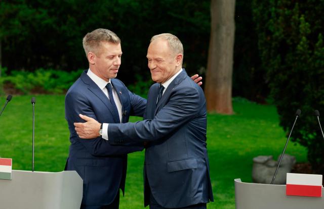 Hungary's Prime Minister Peter Magyar (L) and Poland's Prime Minister Donald Tusk hug at the end of a joint press conference at the garden of the Polish Prime Minister's residency in Warsaw, Poland, on May 20, 2026. Hungary's new Prime Minister Peter Magyar is on a two-day visit to Poland for his first official trip abroad, hoping to mark his country's re-alignment with the European Union after years of open conflict under his predecessor. (Photo by Wojtek RADWANSKI / AFP)