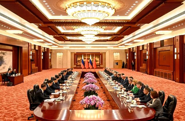 In this pool photograph distributed by the Russian state agency Sputnik, Russia's President Vladimir Putin and Chinese Premier Li Qiang hold a meeting in Beijing on May 20, 2026. (Photo by Kristina Solovyova / POOL / AFP)