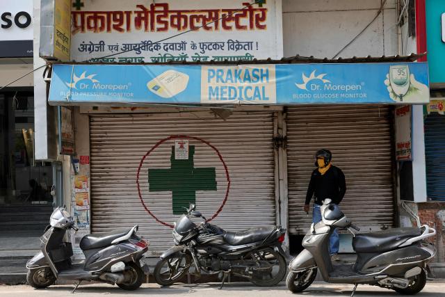 A man stands in front of closed chemist’s shops during a nationwide strike by the All India Organisation of Chemists and Druggists (AIOCD) protesting against e-pharmacy platforms and demanding stricter government regulations over the online sale of medicines in Varanasi on May 20, 2026. (Photo by Niharika KULKARNI / AFP)