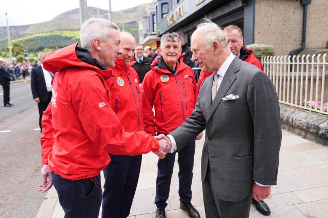 Britain's King Charles III meets members of the Mourne Mountain Rescue service after a visit to Donard Methodist Church in Newcastle, south of Belfast, Northern Ireland on May 20, 2026, on the second day of a three-day royal visit to Northern Ireland. (Photo by Aaron Chown / POOL / AFP)