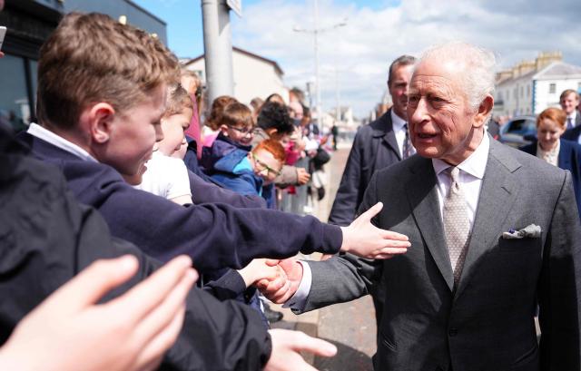 Britain's King Charles III shakes hands with young well-wishers after a visit to the Pantry Foodbank at the Donard Methodist Church in Newcastle, south of Belfast, Northern Ireland on May 20, 2026, on the second day of a three-day royal visit to Northern Ireland. (Photo by Aaron Chown / POOL / AFP)