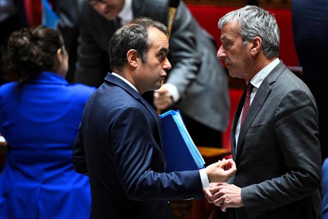 France's Prime Minister Sebastien Lecornu (L) speaks with Les Democrates' MP Philippe Vigier upon arrival for a session of questions to the government at The National Assembly, France's lower house of parliament in Paris on May 20, 2026. (Photo by JULIEN DE ROSA / AFP)