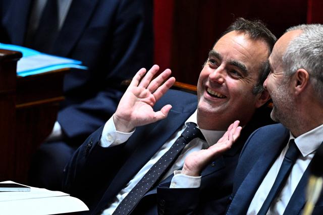 France's Prime Minister Sebastien Lecornu (L) laughs with President of Libertes, Independants, Outre-Mer et Territoires parliamentary group Laurent Panifous (R) during a session of questions to the government at The National Assembly, France's lower house of parliament in Paris on May 20, 2026. (Photo by JULIEN DE ROSA / AFP)