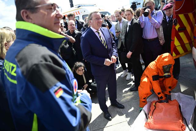 Germany's Interior Minister Alexander Dobrindt (L) and Germany's Defence Minister Boris Pistorius (2nd L) watch a demonstration by first responders on data collection for CBRN-protection (Chemical, Biological, Radiological and Nuclear Hazards) during a hand over of special vehicles for the civil protection to volunteer emergency personnel in Berlin, on May 20, 2026. On May 20, 2026, six CBRN (Chemical, Biological, Radiological and Nuclear Hazards) command personnel carriers for casualty decontamination (MTW Fü Dekon V) and six federal civil protection ambulances (KTW Typ B) from the Federal Office of Civil Protection and Disaster Assistance (BBK) are handed over to emergency services of the States of Berlin, Brandenburg and Thuringia, as well as a THW personnel carrier to Baden-Württemberg. (Photo by John MACDOUGALL / AFP)