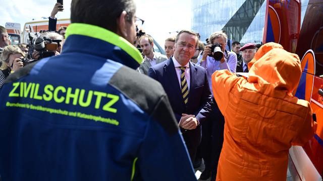 Germany's Interior Minister Alexander Dobrindt (L) and Germany's Defence Minister Boris Pistorius (C) watch a demonstration by first responders on data collection for CBRN-protection (Chemical, Biological, Radiological and Nuclear Hazards) during a hand over of special vehicles for the civil protection to volunteer emergency personnel in Berlin, on May 20, 2026. On May 20, 2026, six CBRN (Chemical, Biological, Radiological and Nuclear Hazards) command personnel carriers for casualty decontamination (MTW Fü Dekon V) and six federal civil protection ambulances (KTW Typ B) from the Federal Office of Civil Protection and Disaster Assistance (BBK) are handed over to emergency services of the States of Berlin, Brandenburg and Thuringia, as well as a THW personnel carrier to Baden-Württemberg. (Photo by John MACDOUGALL / AFP)