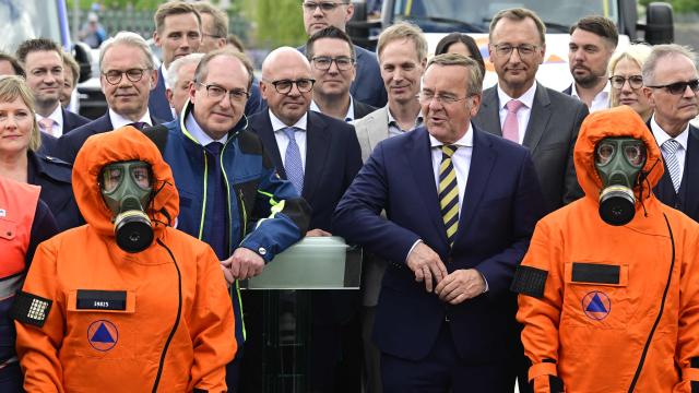 Germany's Interior Minister Alexander Dobrindt (C-L) and Germany's Defence Minister Boris Pistorius (C-R)pose with first responders during a hand over of special vehicles for the civil protection to volunteer emergency personnel in Berlin, on May 20, 2026. On May 20, 2026, six CBRN (Chemical, Biological, Radiological and Nuclear Hazards) command personnel carriers for casualty decontamination (MTW Fü Dekon V) and six federal civil protection ambulances (KTW Typ B) from the Federal Office of Civil Protection and Disaster Assistance (BBK) are handed over to emergency services of the States of Berlin, Brandenburg and Thuringia, as well as a THW personnel carrier to Baden-Württemberg. (Photo by John MACDOUGALL / AFP)