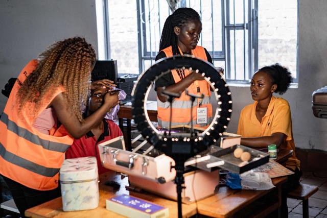 Senior year students at St. Julian High School apply makeup and style their hair while getting ready to attend their prom party themed “A Night in Italy” in Gayaza, on May 19, 2026. Uganda’s high school proms, influenced by global youth and celebrity culture and amplified by social media, have become lavish celebrations blending fashion, creativity and status with local styles of celebration. Mostly seen in elite and urban schools, the events feature themed decor, luxury arrivals and elaborate outfits, with some students previously making headlines for arriving by helicopter before the government banned helicopters and luxury SUV's at school events. Schools balance student expression and modern trends with cultural values and stricter government regulations. (Photo by Badru Katumba / AFP)