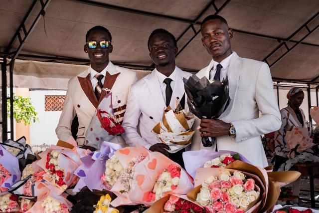 Senior year students at St. Julian High School pose for a picture while picking flower bouquets before attending their prom party themed “A Night in Italy” in Gayaza, on May 19, 2026. Uganda’s high school proms, influenced by global youth and celebrity culture and amplified by social media, have become lavish celebrations blending fashion, creativity and status with local styles of celebration. Mostly seen in elite and urban schools, the events feature themed decor, luxury arrivals and elaborate outfits, with some students previously making headlines for arriving by helicopter before the government banned helicopters and luxury SUV's at school events. Schools balance student expression and modern trends with cultural values and stricter government regulations. (Photo by Badru Katumba / AFP)