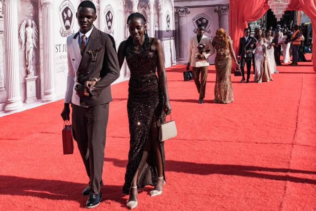 Senior year students at St. Julian High School arrive for their prom party themed “A Night in Italy” in Gayaza, on May 19, 2026. Uganda’s high school proms, influenced by global youth and celebrity culture and amplified by social media, have become lavish celebrations blending fashion, creativity and status with local styles of celebration. Mostly seen in elite and urban schools, the events feature themed decor, luxury arrivals and elaborate outfits, with some students previously making headlines for arriving by helicopter before the government banned helicopters and luxury SUV's at school events. Schools balance student expression and modern trends with cultural values and stricter government regulations. (Photo by Badru Katumba / AFP)