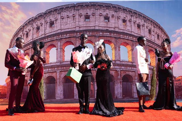 Senior year students at St. Julian High School pose for pictures during their arrival at their prom party themed “A Night in Italy” in Gayaza, on May 19, 2026. Uganda’s high school proms, influenced by global youth and celebrity culture and amplified by social media, have become lavish celebrations blending fashion, creativity and status with local styles of celebration. Mostly seen in elite and urban schools, the events feature themed decor, luxury arrivals and elaborate outfits, with some students previously making headlines for arriving by helicopter before the government banned helicopters and luxury SUV's at school events. Schools balance student expression and modern trends with cultural values and stricter government regulations. (Photo by Badru Katumba / AFP)