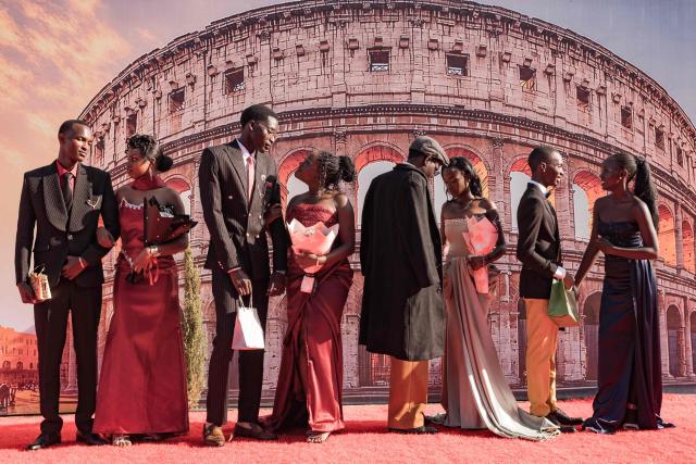 Senior year students at St. Julian High School pose for pictures during their arrival at their prom party themed “A Night in Italy” in Gayaza, on May 19, 2026. Uganda’s high school proms, influenced by global youth and celebrity culture and amplified by social media, have become lavish celebrations blending fashion, creativity and status with local styles of celebration. Mostly seen in elite and urban schools, the events feature themed decor, luxury arrivals and elaborate outfits, with some students previously making headlines for arriving by helicopter before the government banned helicopters and luxury SUV's at school events. Schools balance student expression and modern trends with cultural values and stricter government regulations. (Photo by Badru Katumba / AFP)
