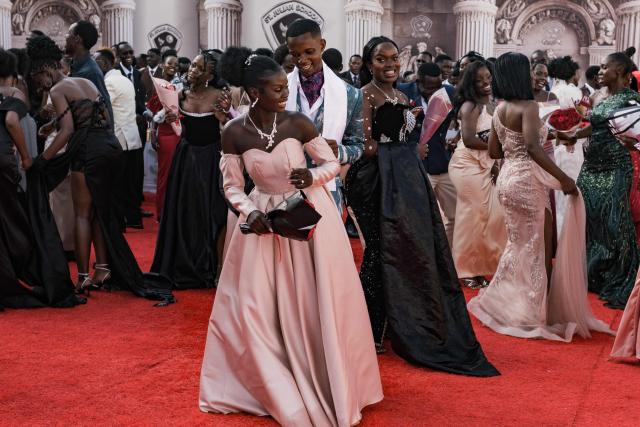 Senior year students at St. Julian High School dance on the red carpet during their prom party themed “A Night in Italy” in Gayaza, on May 19, 2026. Uganda’s high school proms, influenced by global youth and celebrity culture and amplified by social media, have become lavish celebrations blending fashion, creativity and status with local styles of celebration. Mostly seen in elite and urban schools, the events feature themed decor, luxury arrivals and elaborate outfits, with some students previously making headlines for arriving by helicopter before the government banned helicopters and luxury SUV's at school events. Schools balance student expression and modern trends with cultural values and stricter government regulations. (Photo by Badru Katumba / AFP)