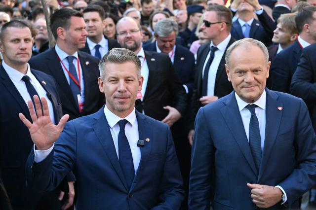 Poland's Prime Minister Donald Tusk (R) and Hungary's Prime Minister Peter Magyar (L) react upon arrival for a meeting with former leader of Solidarnosc and former President of Poland Lech Walesa (unseen) in Gdansk, Poland, on May 20, 2026. Hungary's new Prime Minister Peter Magyar is on a two-day visit to Poland for his first official trip abroad, hoping to mark his country's re-alignment with the European Union after years of open conflict under his predecessor. (Photo by Sergei GAPON / AFP)