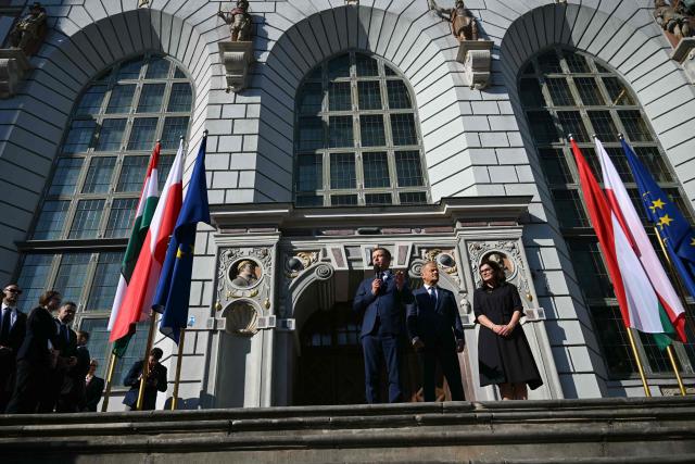 Poland's Prime Minister Donald Tusk (C) and Hungary's Prime Minister Peter Magyar (L) address supporters in Gdansk, Poland, on May 20, 2026. Hungary's new Prime Minister Peter Magyar is on a two-day visit to Poland for his first official trip abroad, hoping to mark his country's re-alignment with the European Union after years of open conflict under his predecessor. (Photo by Sergei GAPON / AFP)