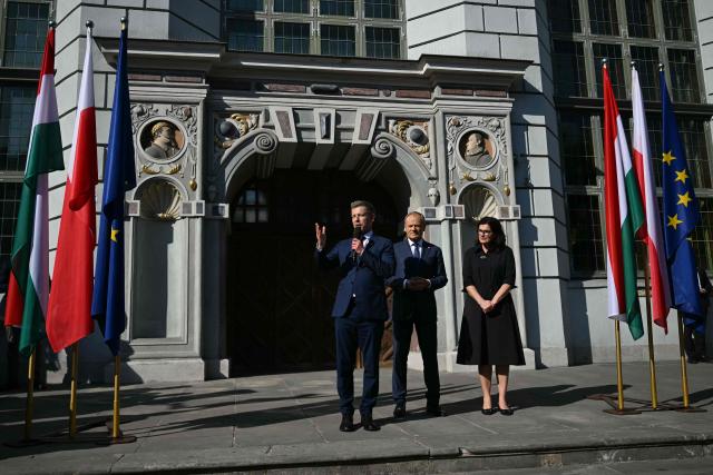 Poland's Prime Minister Donald Tusk (C) and Hungary's Prime Minister Peter Magyar (L) address supporters in Gdansk, Poland, on May 20, 2026. Hungary's new Prime Minister Peter Magyar is on a two-day visit to Poland for his first official trip abroad, hoping to mark his country's re-alignment with the European Union after years of open conflict under his predecessor. (Photo by Sergei GAPON / AFP)