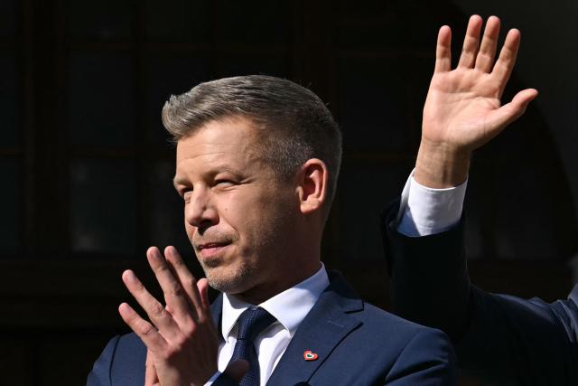 Poland's Prime Minister Donald Tusk (R) and Hungary's Prime Minister Peter Magyar (L) wave to supporters after a meeting with former leader of Solidarnosc and former President of Poland Lech Walesa (unseen) in Gdansk, Poland, on May 20, 2026. Hungary's new Prime Minister Peter Magyar is on a two-day visit to Poland for his first official trip abroad, hoping to mark his country's re-alignment with the European Union after years of open conflict under his predecessor. (Photo by Sergei GAPON / AFP)
