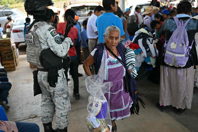 A Nahua indigenous woman leaves after receiving humanitaria aid in Alcozacan, a community affected by drug-related violence, in Guerero state, Mexico, on May 19, 2026 (Photo by YURI CORTEZ / AFP)