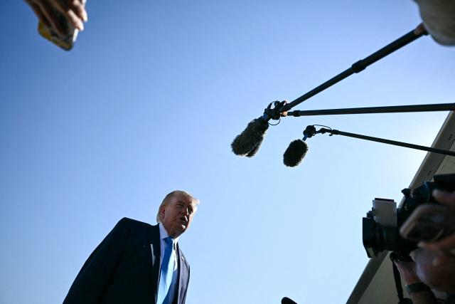 US President Donald Trump speaks to reporters before boarding Air Force One at Joint Base Andrews, Maryland on May 20, 2026. Trump is heading to New London, Connecticut, to deliver the commencement address to the US Coast Guard Academy's 2026 graduating class. (Photo by Kent NISHIMURA / AFP)