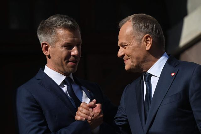 Poland's Prime Minister Donald Tusk (R) shakes hands with Hungary's Prime Minister Peter Magyar (L) during a rally in Gdansk on May 20, 2026. Hungary's new Prime Minister Peter Magyar is on a two-day visit to Poland for his first official trip abroad, hoping to mark his country's re-alignment with the European Union after years of open conflict under his predecessor. (Photo by Sergei GAPON / AFP)