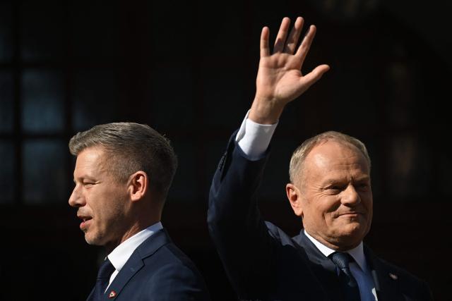 Poland's Prime Minister Donald Tusk (R) and Hungary's Prime Minister Peter Magyar greet supporters during a rally in Gdansk on May 20, 2026. Hungary's new Prime Minister Peter Magyar is on a two-day visit to Poland for his first official trip abroad, hoping to mark his country's re-alignment with the European Union after years of open conflict under his predecessor. (Photo by Sergei GAPON / AFP)