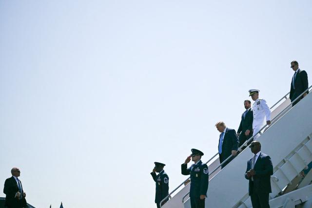US President Donald Trump, trailed by Department of Homeland Security Secretary Markwayne Mullin and US Coast Guard Commandant Admiral Kevin E. Lunday, steps off Air Force One upon arrival at Groton–New London Airport in Groton, Connecticut, on May 20, 2026. Trump is heading to New London to deliver the keynote speech to the US Coast Guard Academy's 2026 graduating class. (Photo by Kent NISHIMURA / AFP)
