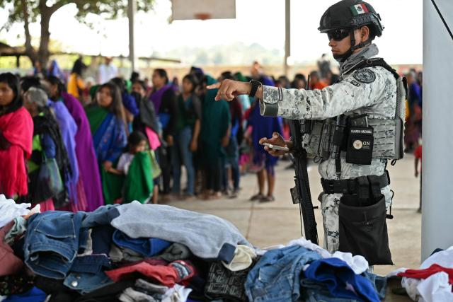 A member of the National Guard is seen as Nahua indigenous women receive humanitaria aid in Alcozacan, a community affected by drug-related violence, in Guerero state, Mexico, on May 19, 2026 (Photo by YURI CORTEZ / AFP)