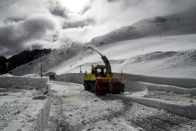 A worker drives a snowplough to clear snow from the Galibier Pass, a mountain road in the Dauphine Alps, above Valloire, eastern France, on May 20, 2026. (Photo by Jeff PACHOUD / AFP)