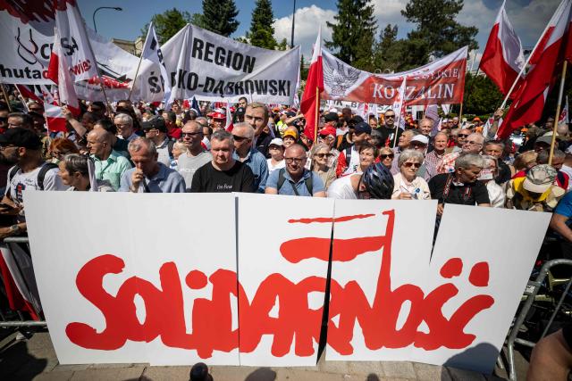 Protesters hold banners in front of a huge inscription reading “Solidarity” during a demonstration of the “Solidarity” trade union and right-wing supporters against the European Green Deal and the policies of Donald Tusk’s government in front the Polish parliament, the Sejm, in Warsaw, Poland, on May 20, 2026. (Photo by Wojtek RADWANSKI / AFP)