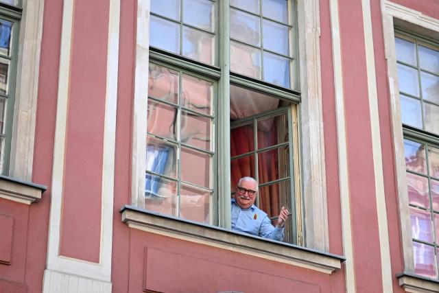Former leader of Solidarnosc and former Polish President Lech Walesa greets supporters from the window of Uphagen House following a meeting with Polish and Hungarian prime ministers in Gdansk on May 20, 2026. Hungary's new Prime Minister Peter Magyar is on a two-day visit to Poland for his first official trip abroad, hoping to mark his country's re-alignment with the European Union after years of open conflict under his predecessor. (Photo by Sergei GAPON / AFP)