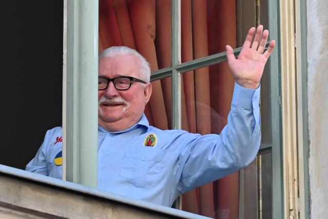 Former leader of Solidarnosc and former Polish President Lech Walesa greets supporters from the window of Uphagen House following a meeting with Polish and Hungarian prime ministers in Gdansk on May 20, 2026. Hungary's new Prime Minister Peter Magyar is on a two-day visit to Poland for his first official trip abroad, hoping to mark his country's re-alignment with the European Union after years of open conflict under his predecessor. (Photo by Sergei GAPON / AFP)