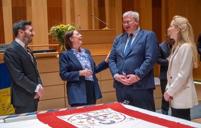 (L-R) Fabian Arnheim, museum director of the Army Museum, Sweden's Minister for Foreign Affairs Maria Malmer Stenergard, Ukraine's Minister for Foreign Affairs Andrii Sybiha and Ukraine's Ambassador to Sweden Svetlana Zalishchuk react during a flag-raising ceremony at the Town Hall in central Kristianstad in connection with the bilateral meeting in Kristianstad, Sweden, on May 20 2026. During his visit to Kristianstad, Ukraine's Minister for Foreign Affairs Andrij Sybiha received a replica of a flag that originally belonged to the Cossack leader Bogdan Khmelnytski. The flag was lost to the Poles but was captured in 1655 by the Swedish military and is kept at the Army Museum in Stockholm. (Photo by Johan NILSSON / TT News Agency / AFP) / Sweden OUT