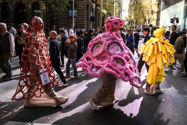Performers wear coral reef-inspired costumes during a show to raise awareness of threats to Australia's Great Barrier Reef in Sydney on May 21, 2026. (Photo by DAVID GRAY / AFP)