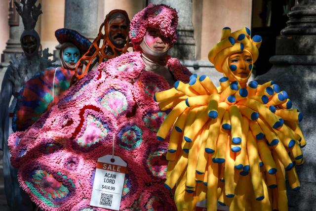 Performers wear coral reef-inspired costumes during a show to raise awareness of threats to Australia's Great Barrier Reef in Sydney on May 21, 2026. (Photo by DAVID GRAY / AFP)