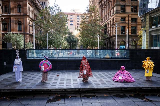 Performers wear coral reef-inspired costumes on a sidewalk during a show to raise awareness of threats to Australia's Great Barrier Reef in Sydney on May 21, 2026. (Photo by DAVID GRAY / AFP)