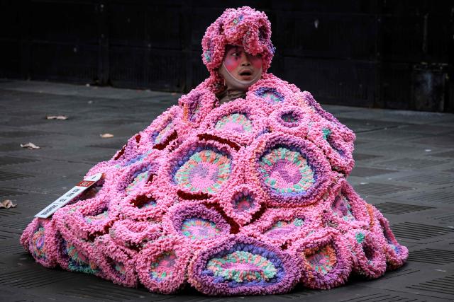 A performer wears a coral reef-inspired costume during a show to raise awareness of threats to Australia's Great Barrier Reef in Sydney on May 21, 2026. (Photo by DAVID GRAY / AFP)