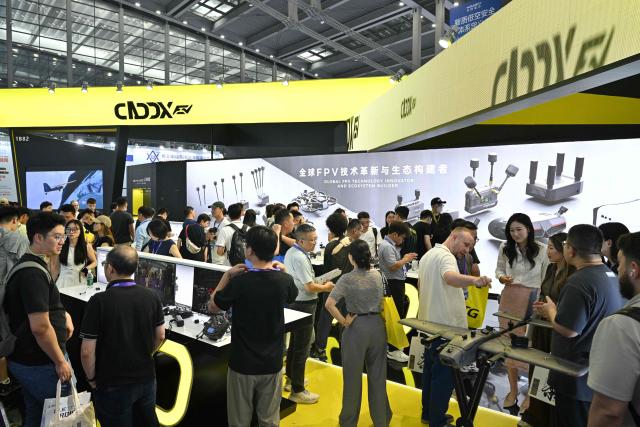 People visit the CADDX FPV booth at the Drone World Congress (DWC) in Shenzhen on May 21, 2026. (Photo by Hector RETAMAL / AFP)