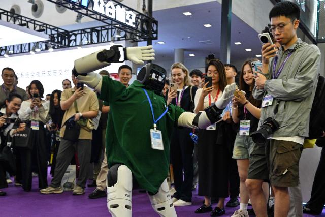 A remote-controlled robot performs at the Drone World Congress (DWC) in Shenzhen on May 21, 2026. (Photo by Hector RETAMAL / AFP)