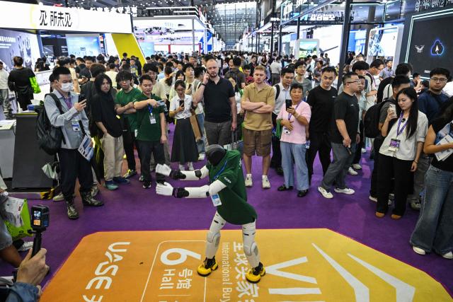 A remote-controlled robot performs at the Drone World Congress (DWC) in Shenzhen on May 21, 2026. (Photo by Hector RETAMAL / AFP)