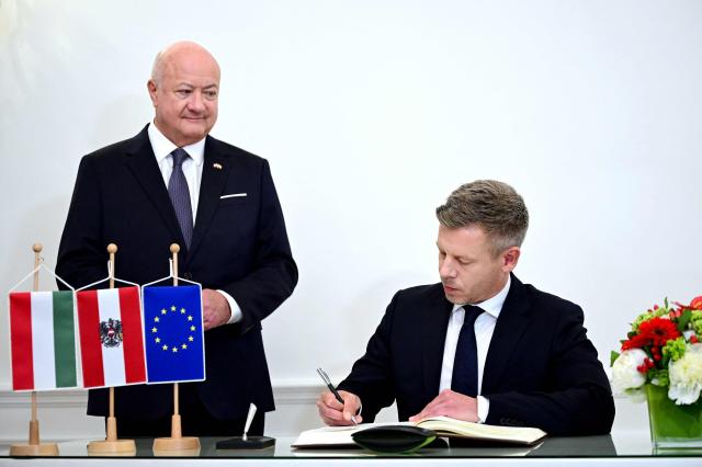 Austrian Chancellor Christian Stocker (L) looks on as Hungarian Prime Minister Peter Magyar signs the guest book during his visit in Vienna, Austria, on May 21, 2026. (Photo by Roland SCHLAGER / APA / AFP) / Austria OUT