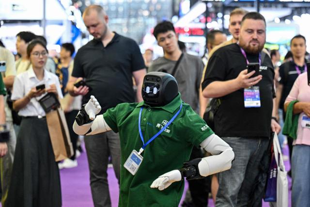 A remote-controlled robot performs at the Drone World Congress (DWC) in Shenzhen on May 21, 2026. (Photo by Hector RETAMAL / AFP)
