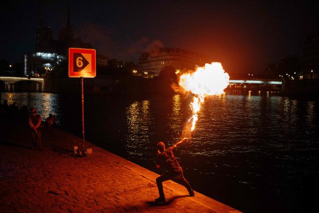 A fire-eater performs on the banks of the Seine River in Paris on May 20, 2026. (Photo by DIMITAR DILKOFF / AFP)